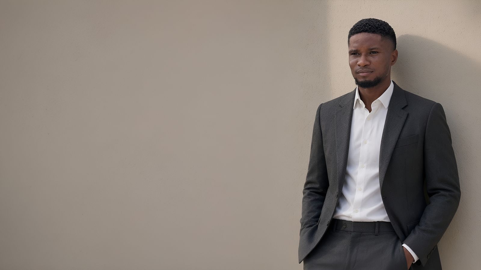 The Quiet Authority: a charcoal suit worn open over a crisp white open-collar shirt